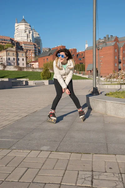 Fille ludique dans un drôle de patinage à roulettes de lunettes de soleil et avoir du plaisir — Photo