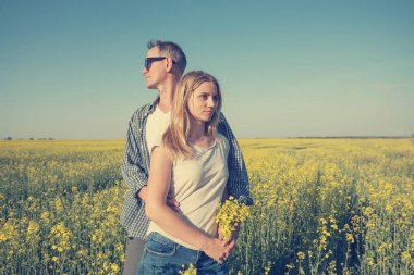 Adam güzel bir genç kadınla kucaklayan, bir alan içinde ayakta