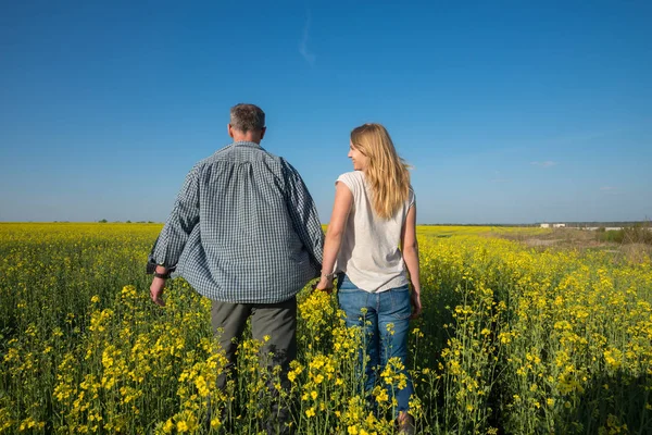 Genç gülümseyen kadın adamla bir alanda yürüyüş 