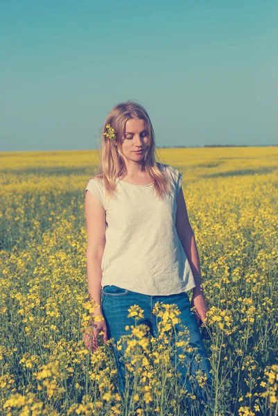 Muhteşem kız, sarışın saçında parlak bir kır çiçeği ile