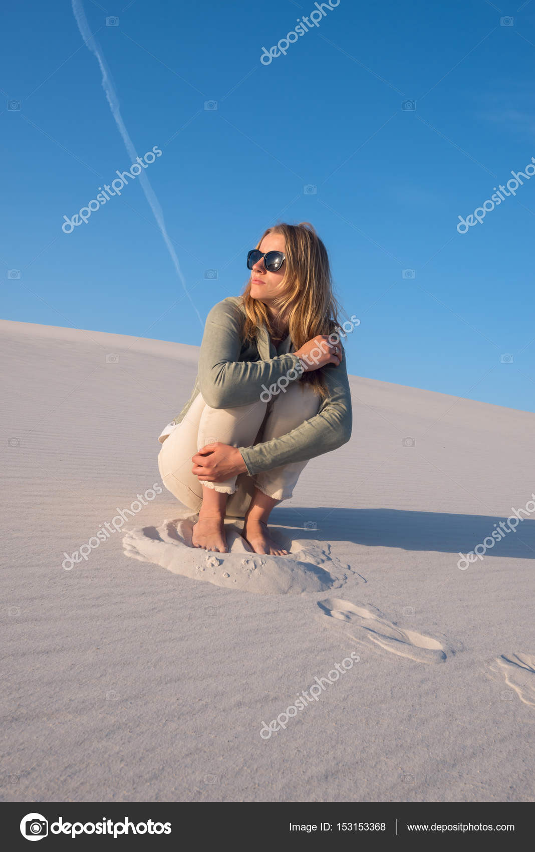 Romantische junge Frau, Blondine sitzt allein am Strand