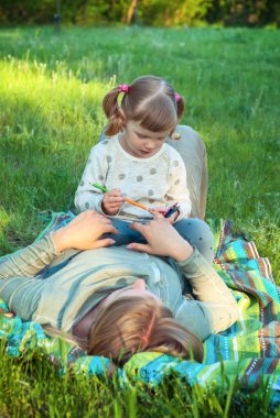 Genç anne oyunları sırasında onlar küçük kızıyla birlikte yalan şunlar