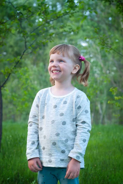 緑の芝生に囲まれた公園で笑顔の少女の肖像画 — ストック写真
