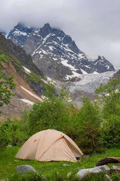 Палатка путешественников рядом с ледником в горном ущелье — стоковое фото