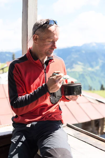 Traveler man  eats from a small bowler