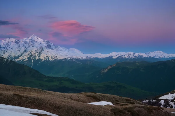 Красочные красные облака плавают над красивой снежной вершиной — стоковое фото