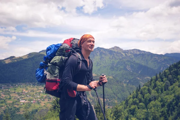 Glücklicher Mann Wanderer in den Bergen vor dem Hintergrund des grünen Hügels — Stockfoto