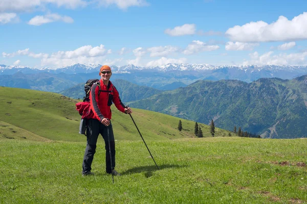 Komik adam Gezgin güneş gözlüğü Alpin çayır yürür 