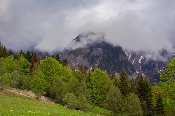 Niedrige schwere Wolken schwimmen über felsigen Klippen — Stockfoto