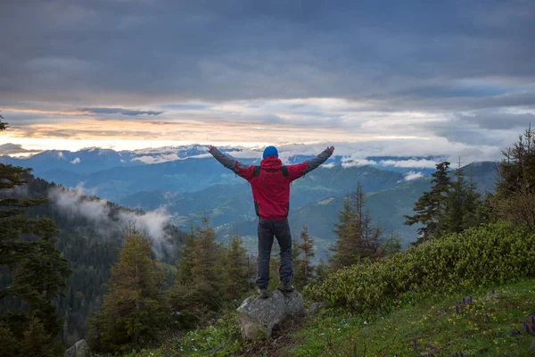 Eenzame reiziger met open armen staat op de klif in de mounta — Stockfoto