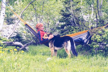 Adam Gezgin hamakta rahatlatıcı ve onun köpekle oynamayı
