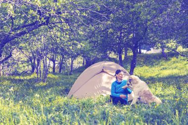 Komik kadın Gezgin çadır yanındaki büyük köpekle oynar 