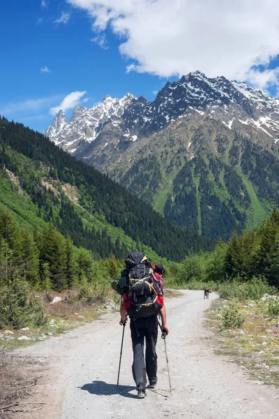 Man avonturier met grote hond loopt op de weg in een berg gorg — Stockfoto