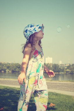 Küçük kız darbeler sabun köpüğü üzerinde