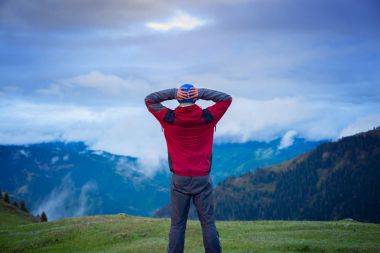 Dağın üstünden ağır bulutlar hareketini seyreden Gezgin