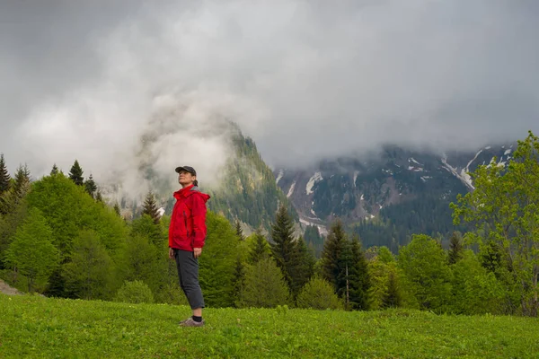 Podróżnik dumna kobieta stoi na alpejskiej łąki — Zdjęcie stockowe