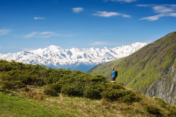 남자 여행자 녹색 산 경사면에 서 있습니다 — 스톡 사진