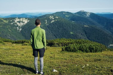 Genç yolcusu Alp çayır üzerinde tek başına duran 