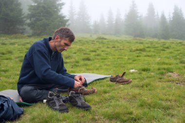 Seyahat ederken ayakkabı konsantre adam onarır