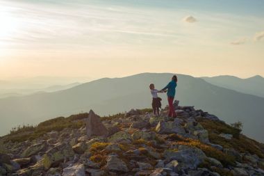 Anne ve kızı, elele, dağın tepesinde iplik