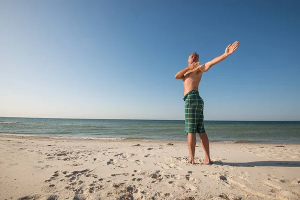 大人の男が海岸でヨガを練習します。 — ストック写真