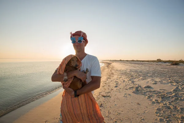 Hombre alegre en unas gafas de sol divertidas con un perro pequeño — Foto de Stock