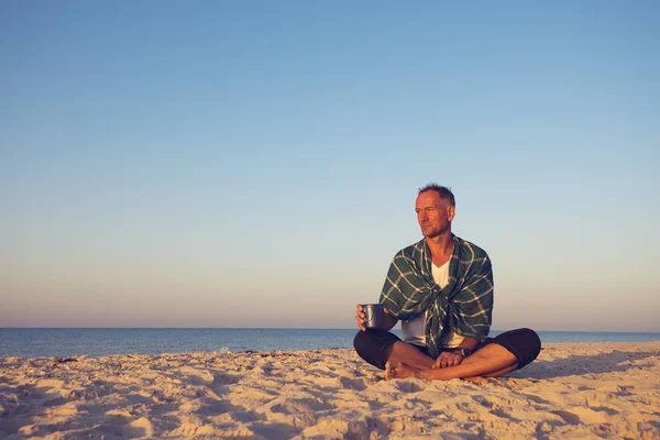 人けのない海岸で座っている男旅行者 — ストック写真