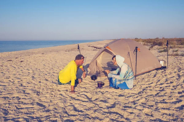 Par av resenärer är avkopplande intill tält — Stockfoto