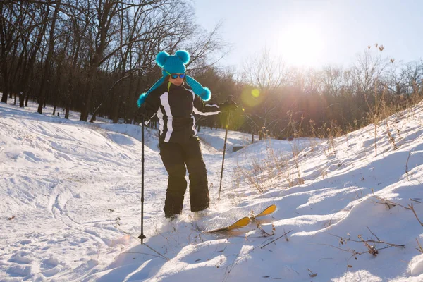 Dívka v srandovní čepici lyžování v lese — Stock fotografie