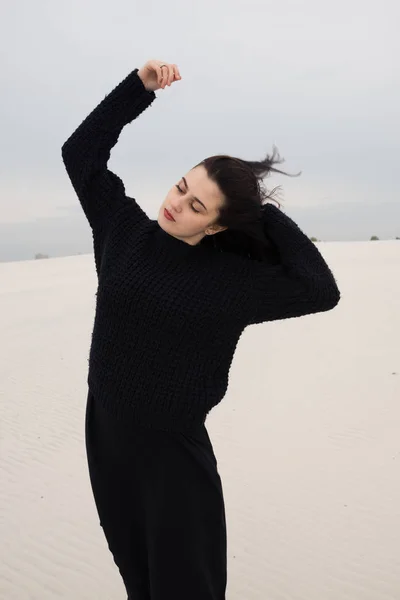 Soñando chica en negro se levanta en el desierto — Foto de Stock