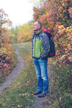 Gezgin bir sırt çantası ile duran, dalgınlık içinde