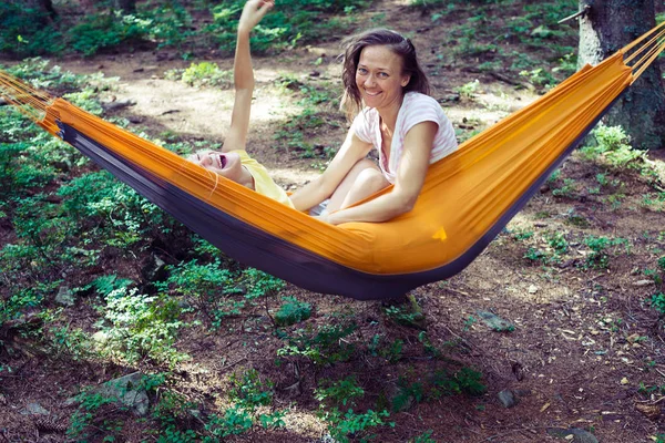 Happy mom and daughter playing in a hammock — Stock Photo, Image