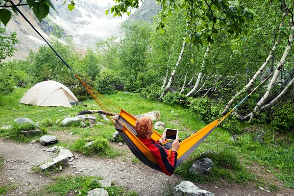 Aventurero relajante en hamaca con tableta — Foto de Stock