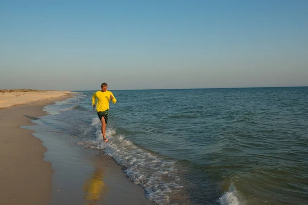 Радостный путешественник бежит вдоль линии серфинга — стоковое фото