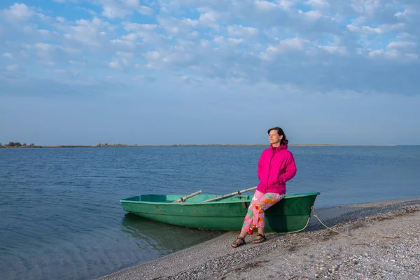 Спортивная женщина в яркой куртке сидит на лодке — стоковое фото