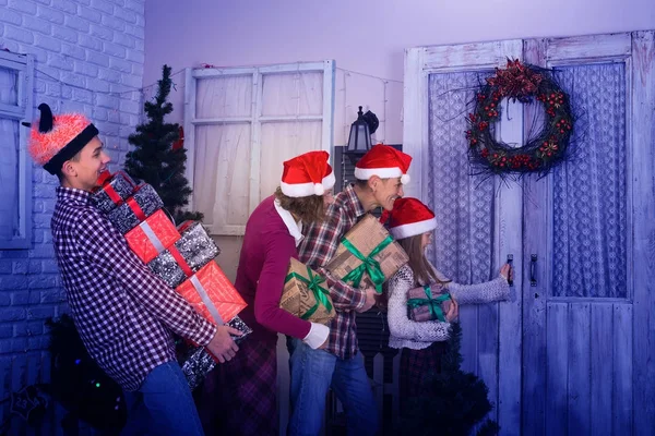 Famille joyeuse, dans un chapeau de Père Noël, va rendre visite à des amis — Photo