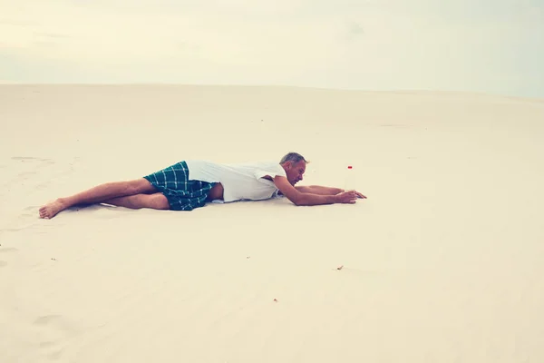 Wyczerpany mężczyzna, stracił na pustyni, wyłazi na piasku — Zdjęcie stockowe