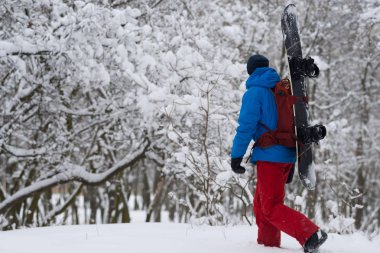 Snowboard sırt çantası ile ormanda yürür