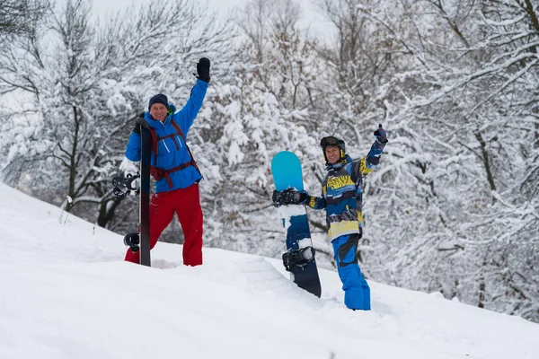 Glad snowboardåkare står i skogen efter snöfall — Stockfoto