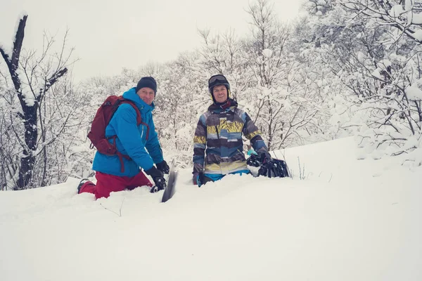 Los snowboarders felices están sentados en la nieve profunda después de freeride — Foto de Stock