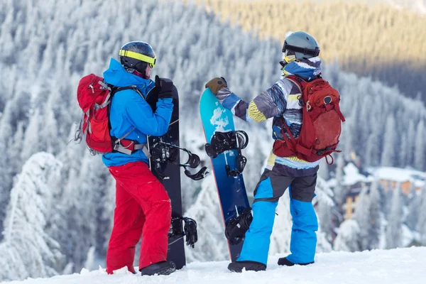 Deux snowboarders, avec des sacs à dos, se tiennent sur la pente de la montagne — Photo