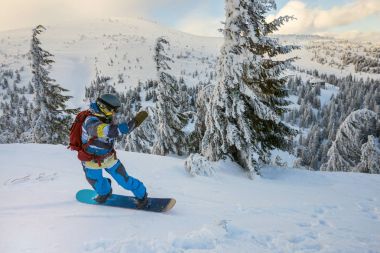 Snowboard ağaçlık tepelerin arka plan üzerinde sürmek