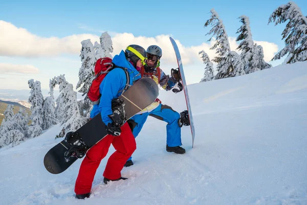 Deux snowboarders heureux grimpent sur la pente de la montagne, parler et lau — Photo