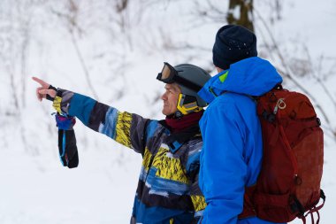 İki snowboard dikkatlice teftiş sırasında iniş site