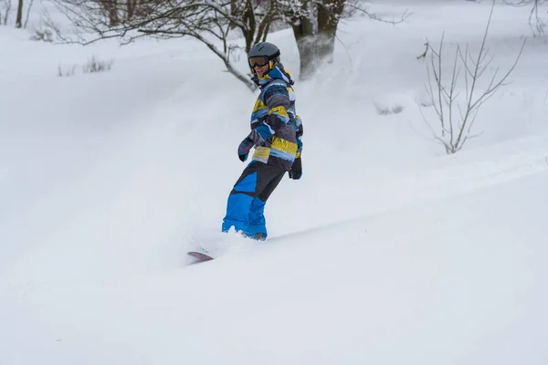 Snowboardåkare rider, i ett moln av snö, under freeride — Stockfoto