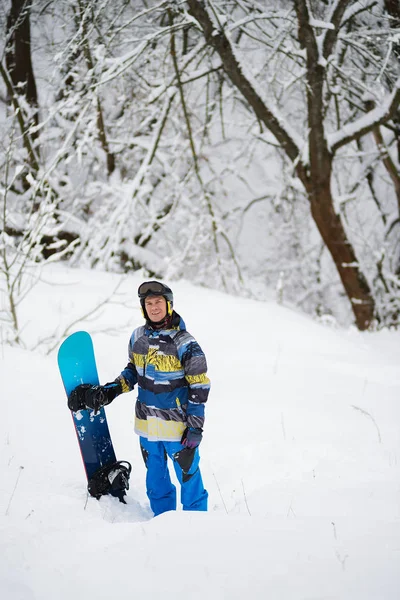 Heureux snowboarder se tient dans la forêt d'hiver après les chutes de neige — Photo