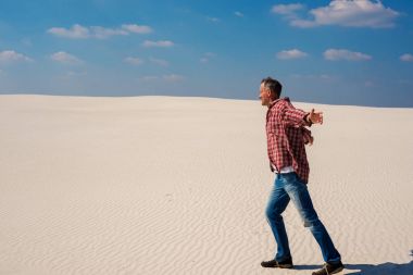 Kollarını açarak, neşeli Gezgin adam çöl yürür