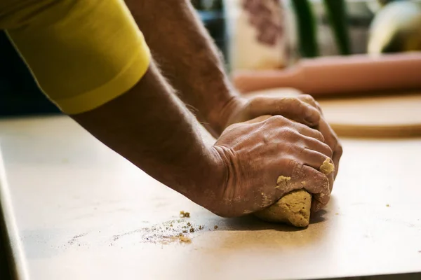 Male hands roll out the dough on the white table — Stock Photo, Image