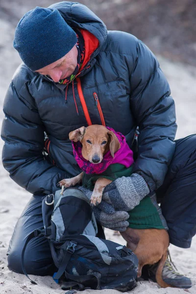 Glimlachende man, wandelaar spelen met zijn grappige kleine hond — Stockfoto