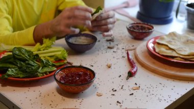 Adam ev yapımı lenten ekmek ve sos ile yeşillik yemek bir masada oturuyor. Evde güzel şenlikli Kahvaltı.